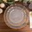 Elegant clear plates with gold edges, stacked on a wooden table.