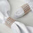 Elegant napkin rings adorned with sparkling crystals on white fabric.