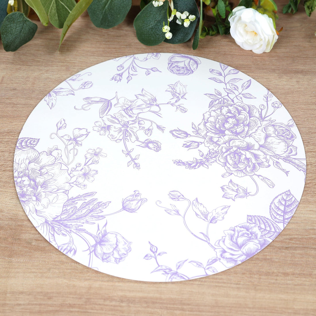 Round floral placemat with purple designs on a white background.