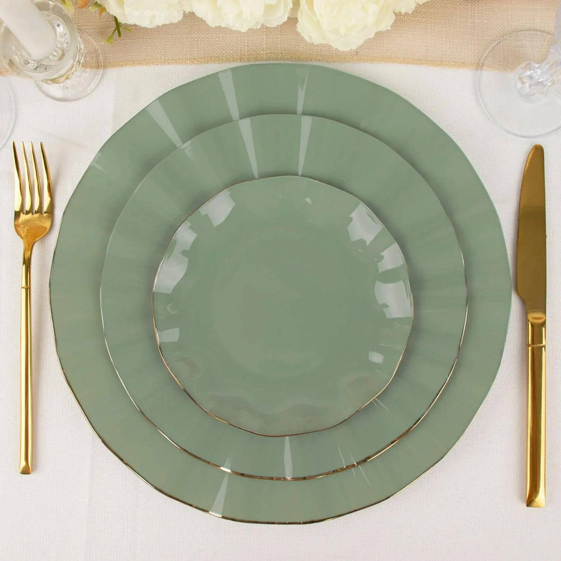 Elegant green dinner plates with gold trim, arranged on a table setting.