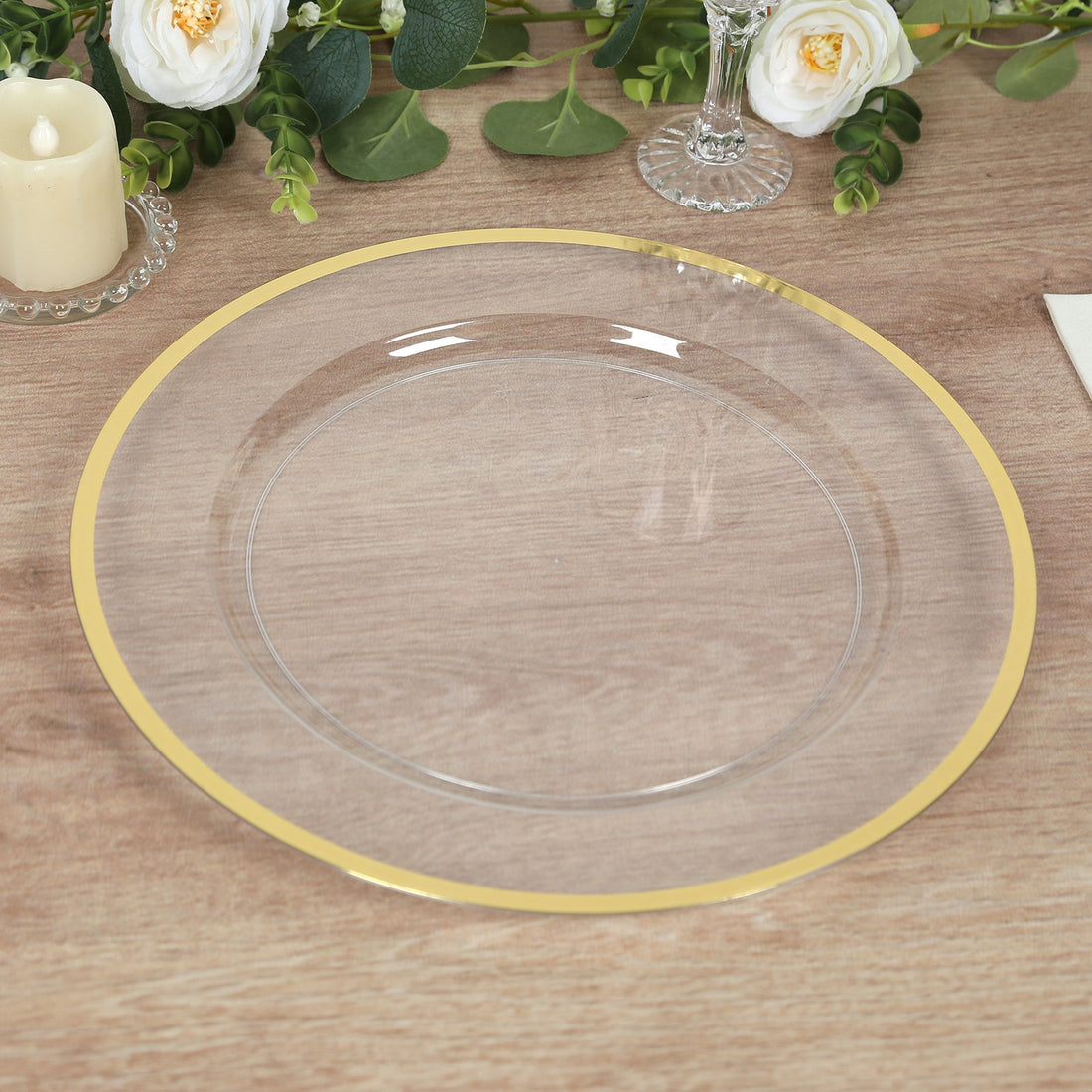 Clear plate with a gold rim on a wooden table.