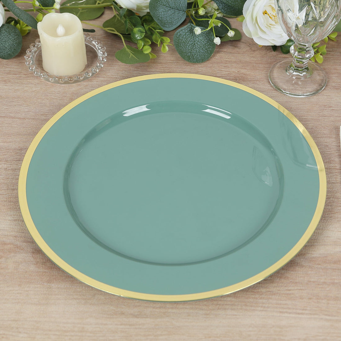 Teal dinner plate with gold rim on a wooden table.