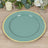 Teal dinner plate with gold rim on a wooden table.