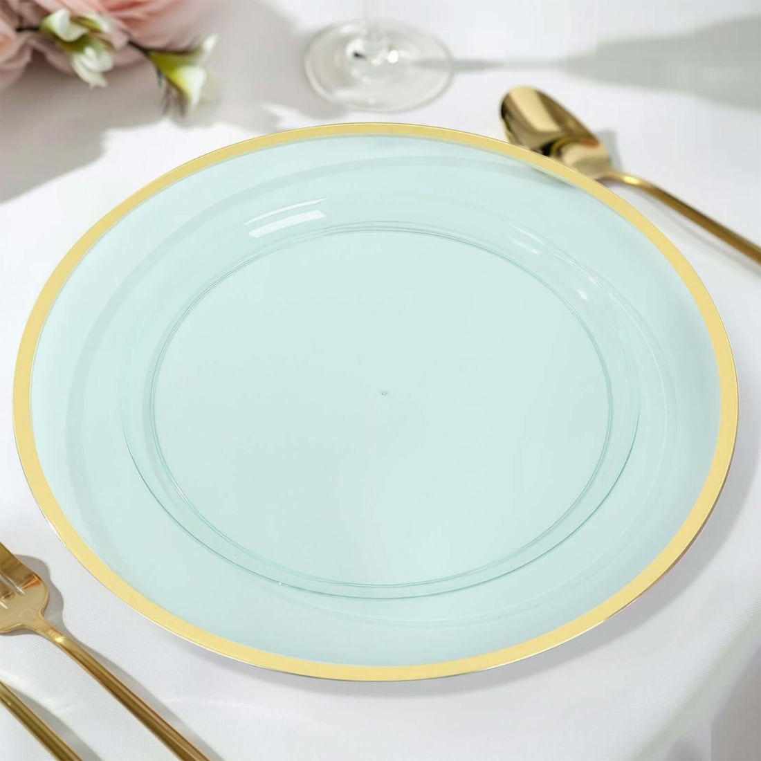 Mint green serving plate with a gold rim on a table setting.
