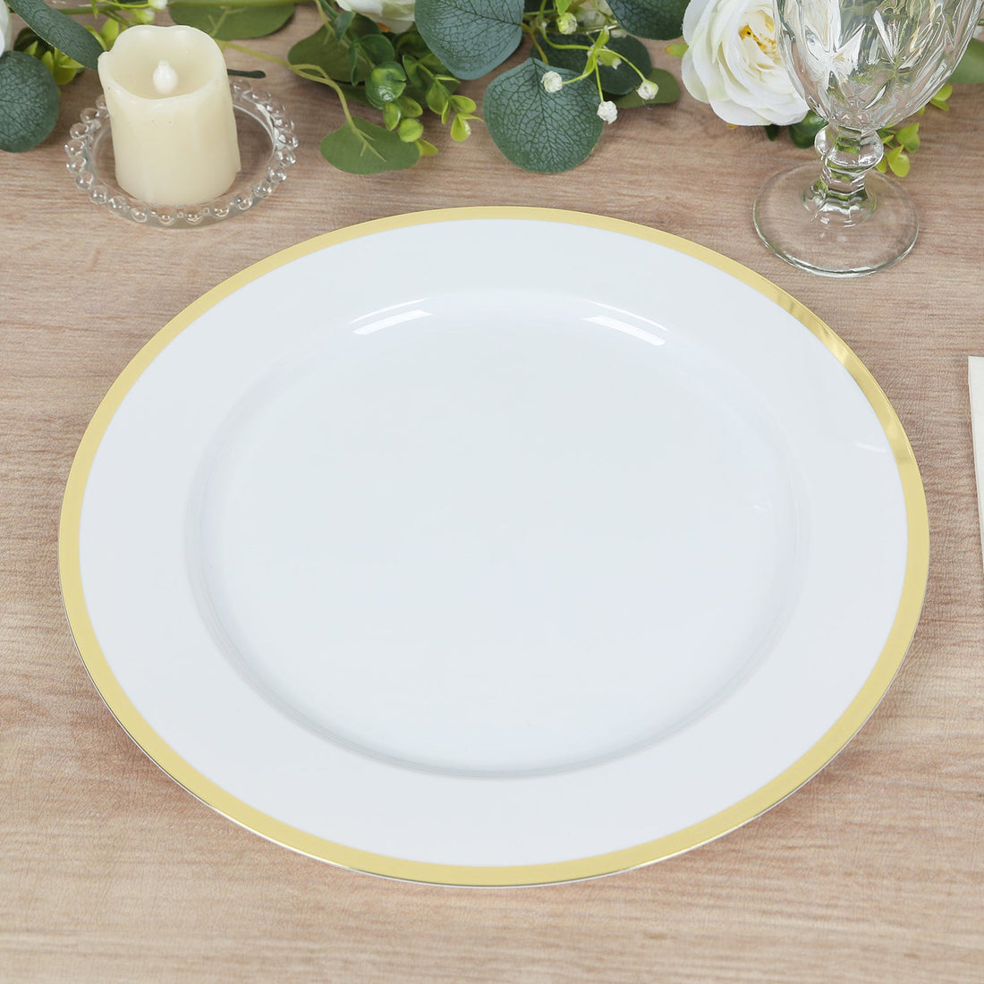 White plate with gold rim on a wooden table setting.