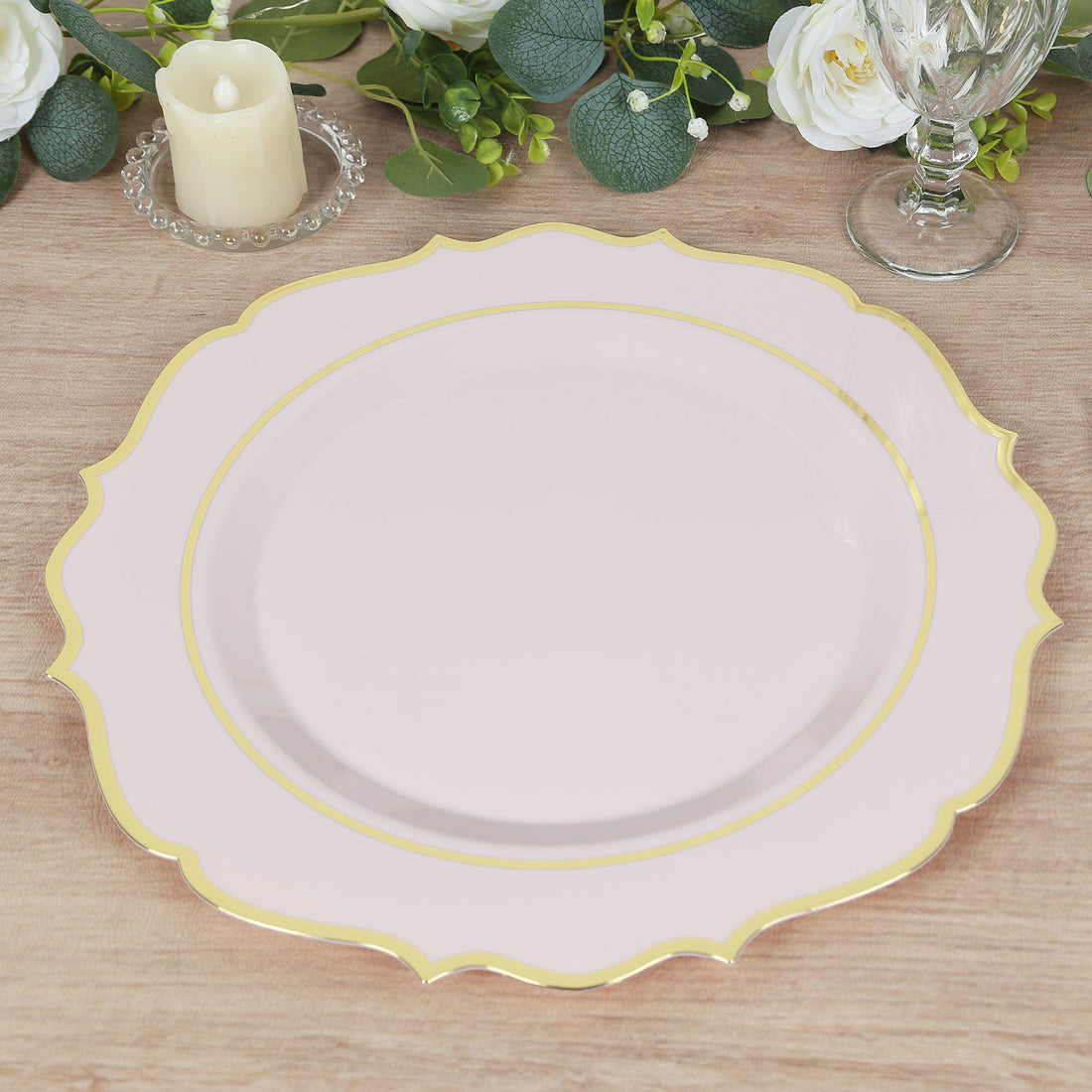 Pink decorative plate with gold trim on a wooden surface.