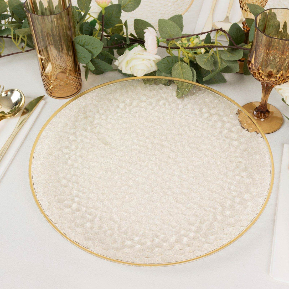 Elegant textured glass serving plate with gold trim on a styled table setting.