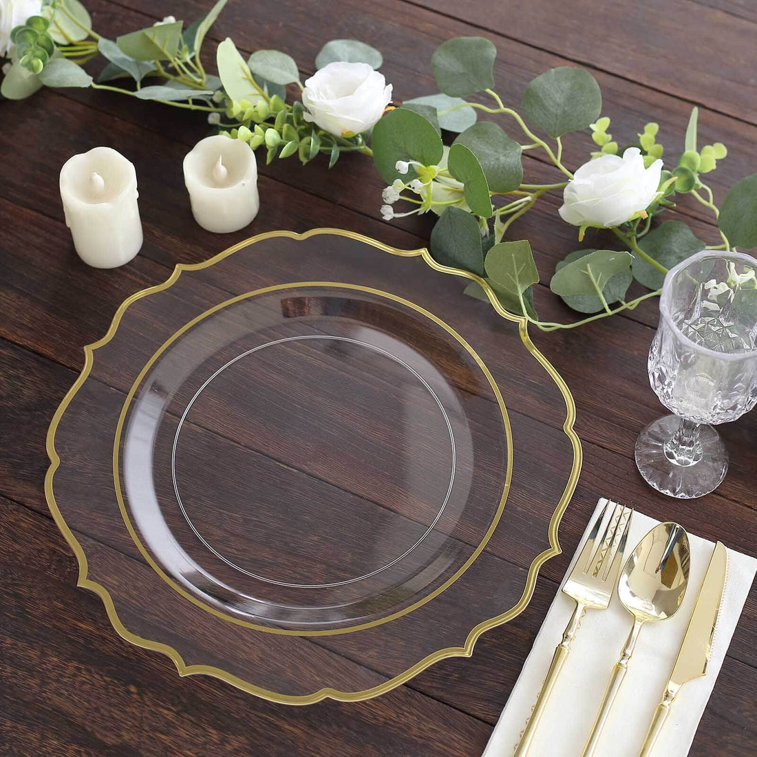 Elegant clear plate with gold trim on a rustic wooden table setting.