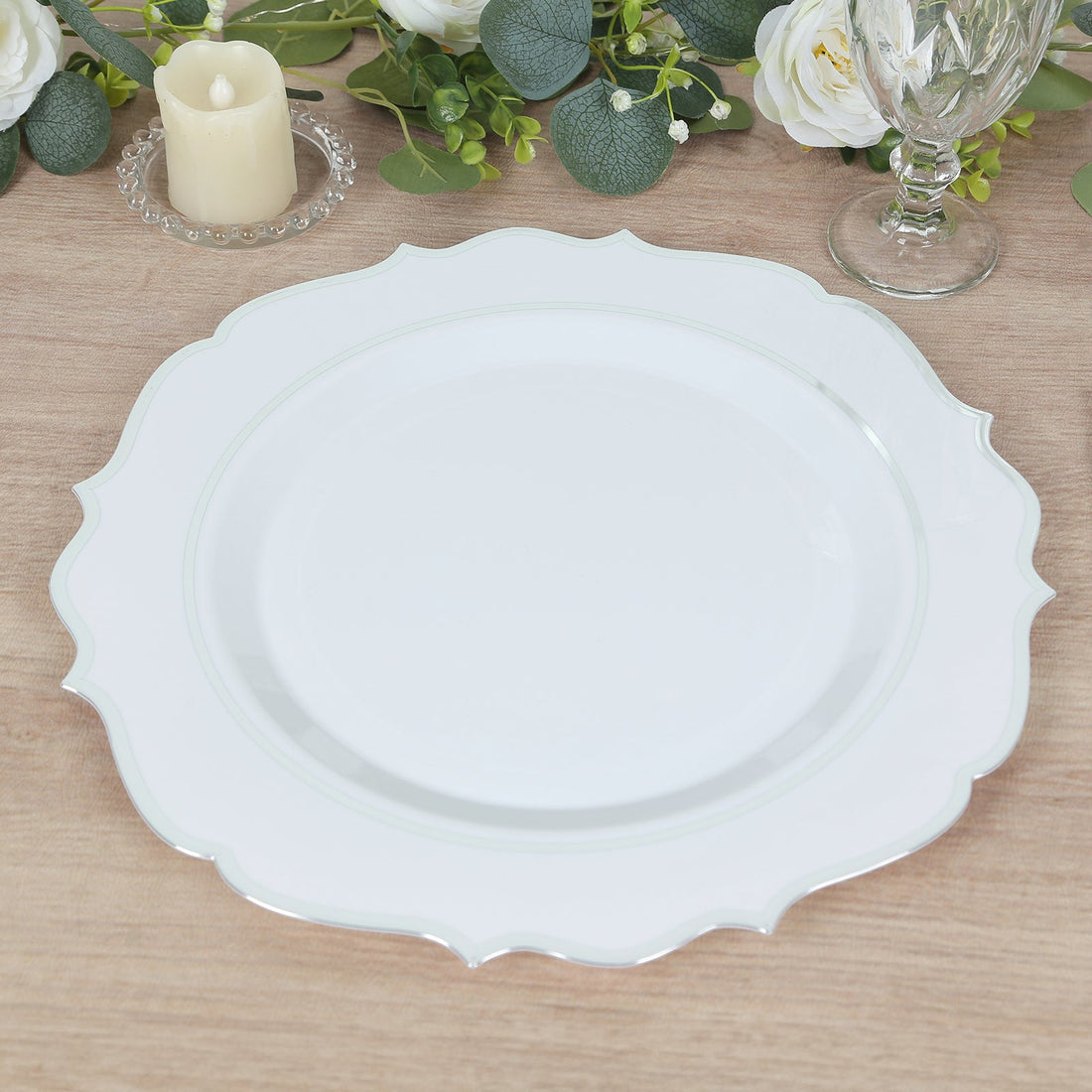 Elegant white decorative plate with scalloped edges on a wooden table.