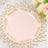 Elegant pink plate with gold floral design on a decorative gold placemat.