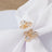 Gold butterfly napkin rings with clear crystals on a white napkin.