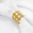 Gold rhinestone napkin ring on a white napkin.