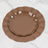 Brown ceramic plates with a scalloped edge and gold trim on a marble surface.