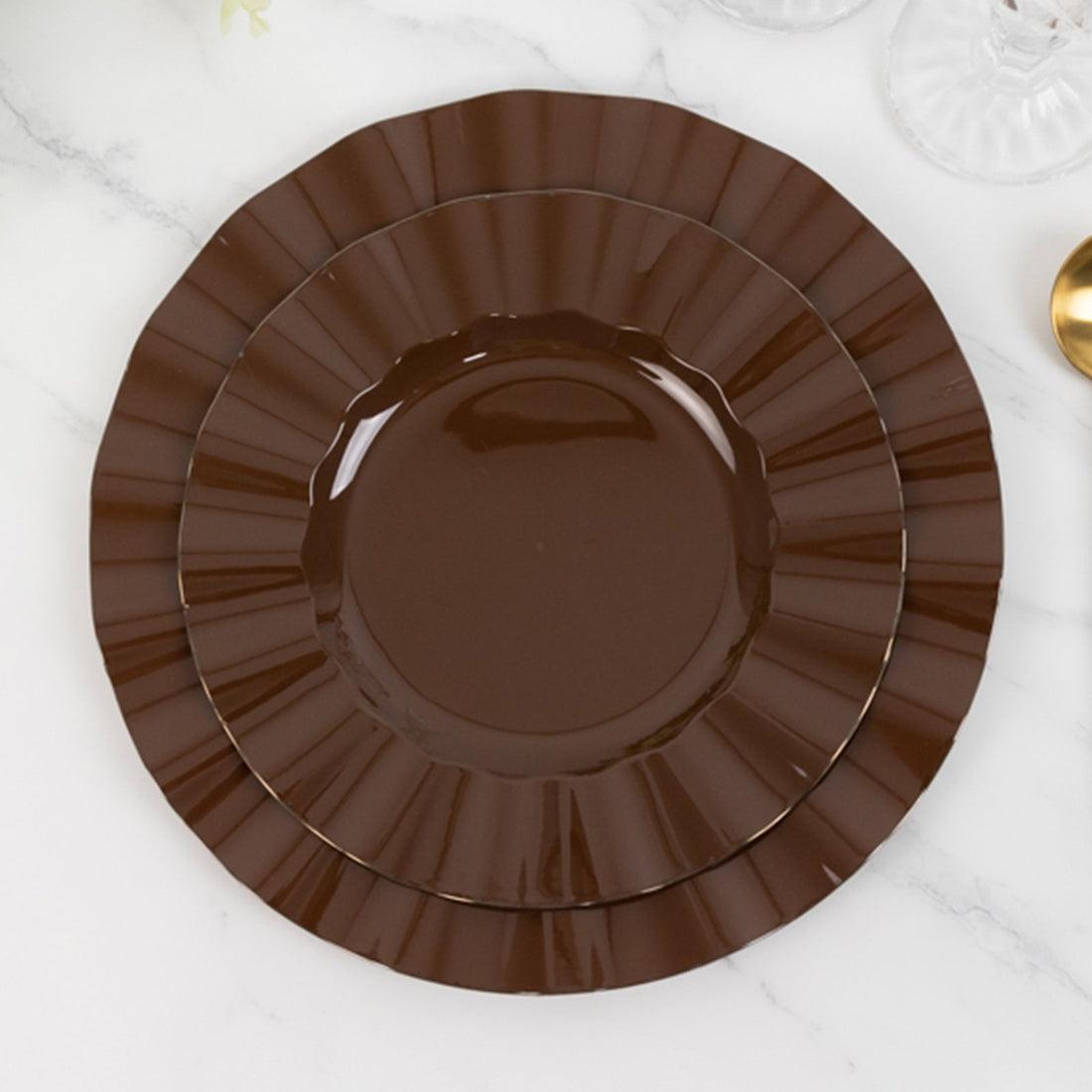 Brown decorative plates stacked on a marble surface.