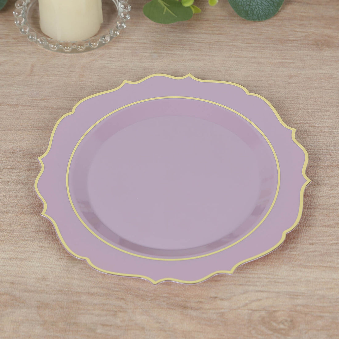 Lavender decorative plate with gold trim on a wooden table.