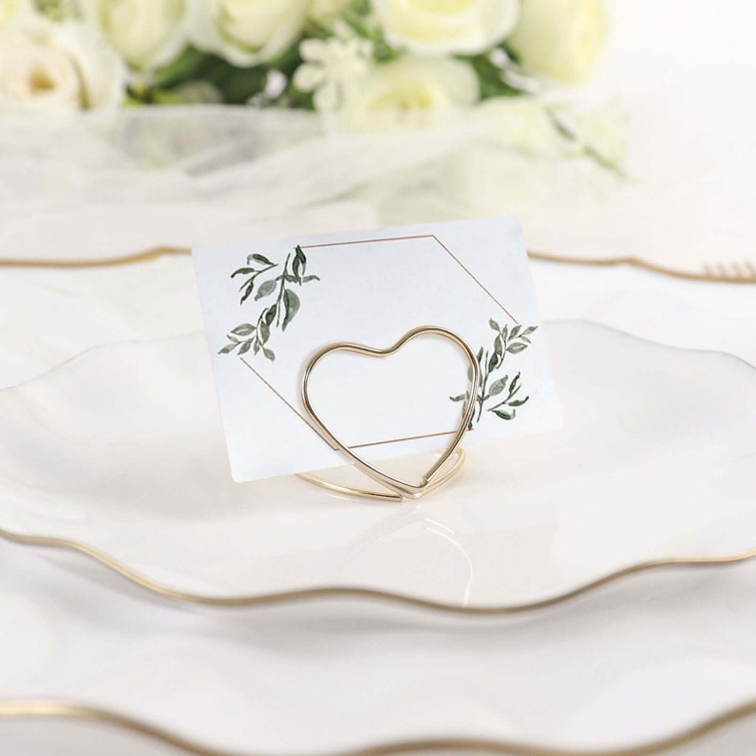 Gold heart-shaped card holder with floral design on a white card.