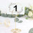 Table number holder with floral design card, ideal for events and weddings.