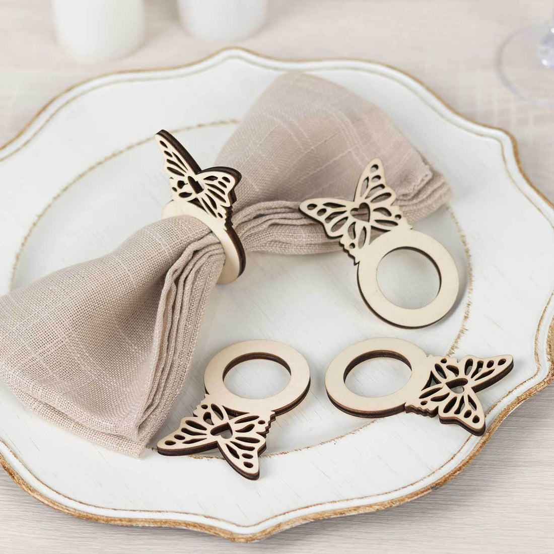 Wooden butterfly napkin rings set on a decorative plate.