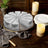 Sliced cake on a serving tray with candles and plates in a rustic setting.
