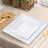 White square dinner and salad plates stacked on a table setting.