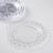 Clear decorative plate with textured rim on a white background.