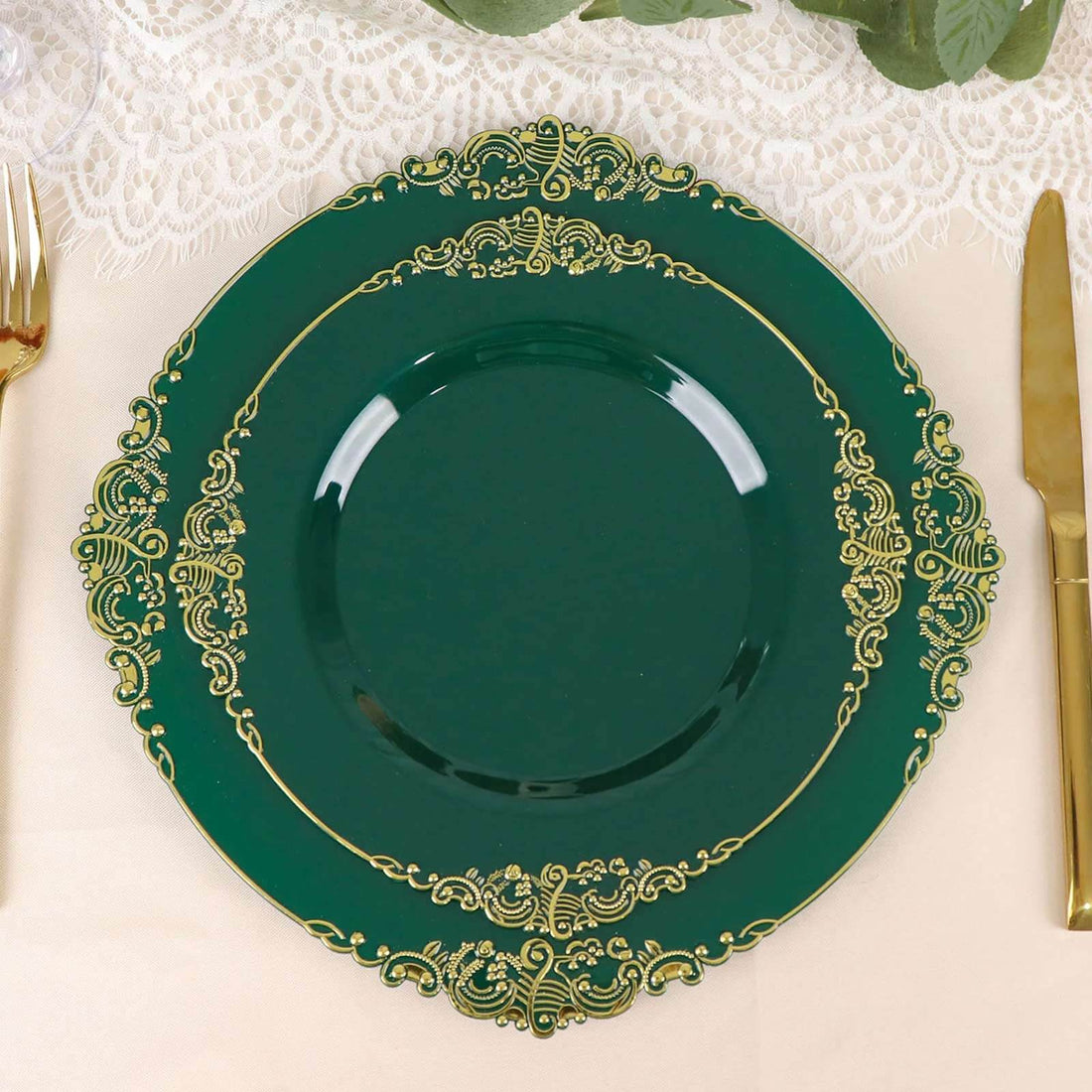 Elegant green plate with gold intricate design on a lace tablecloth.