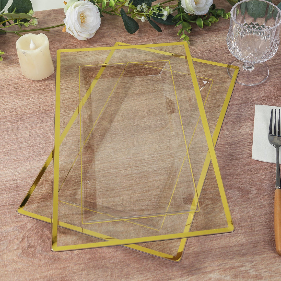 Elegant glass serving trays with gold trim stacked on a wooden table.