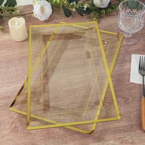 Elegant glass serving trays with gold trim stacked on a wooden table.