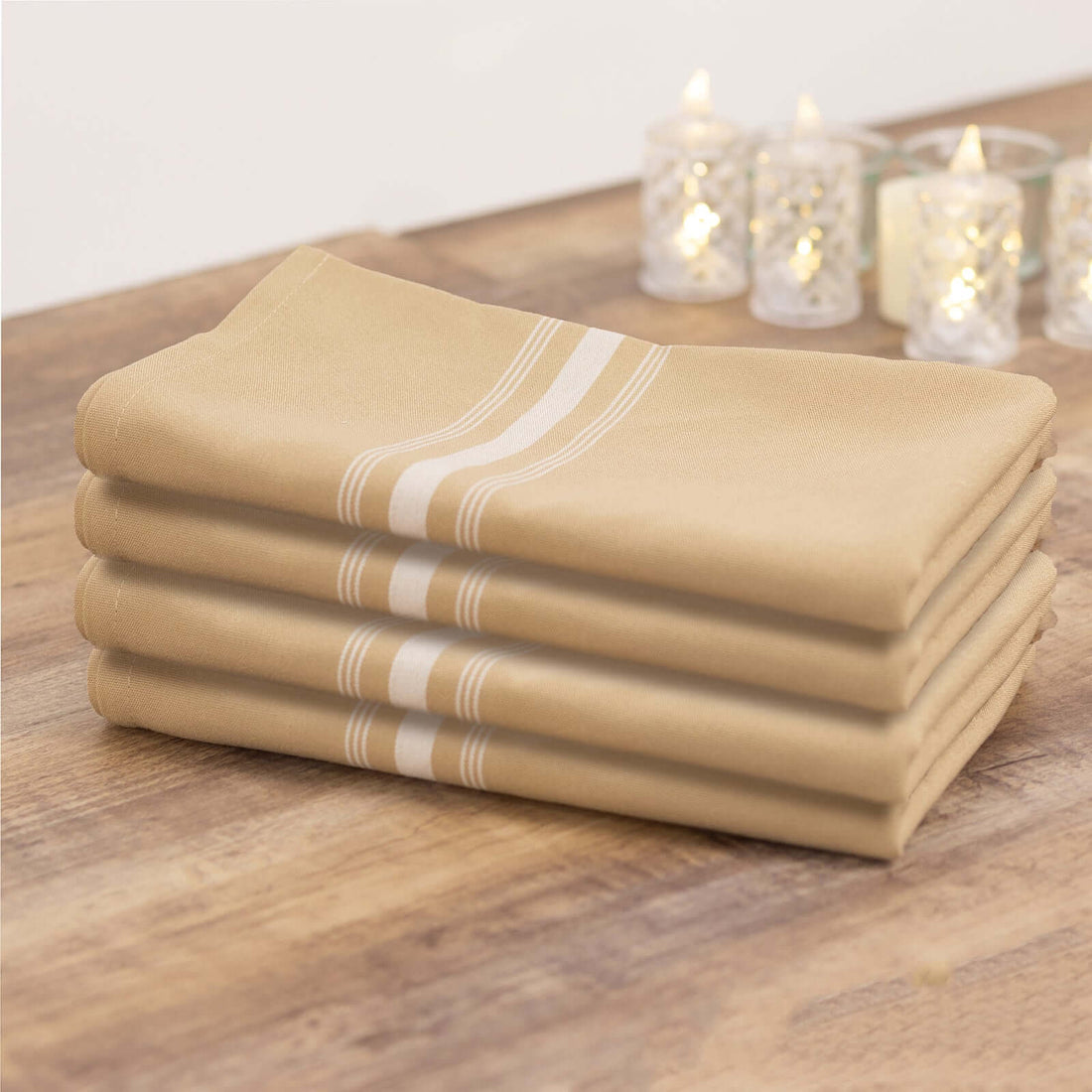 Set of four beige kitchen towels with white stripes.