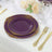 Elegant purple and gold decorative plates on a dining table setting.
