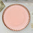 Pink charger plate with a decorative rim on a plain background.