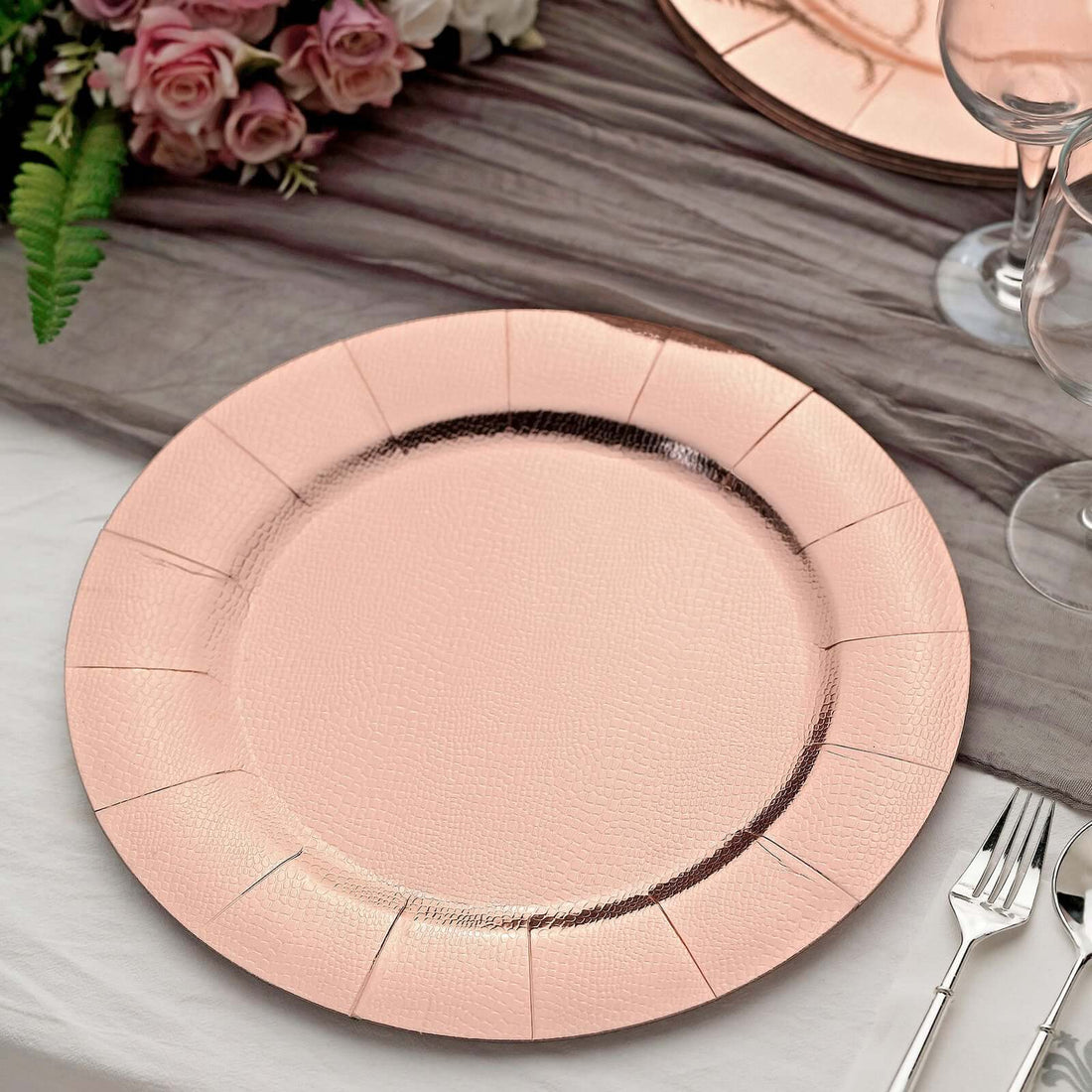 Rose gold textured charger plate on a table setting.