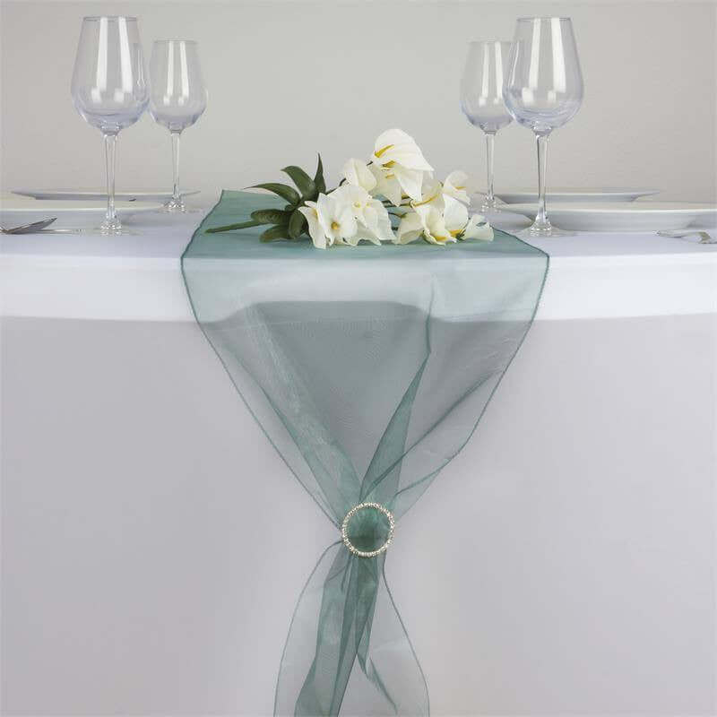 Elegant green table runner with floral arrangement and glassware #whtbkgd