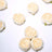 White artificial flowers arranged on a plain background.