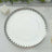 Silver decorative platter with scalloped edge on a white tablecloth.