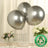 Three silver biodegradable balloons on a table with flowers.