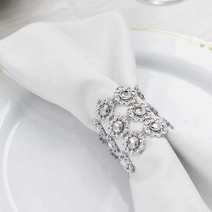 Elegant silver napkin ring adorned with crystals on a white napkin.
