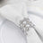 Elegant silver napkin ring adorned with crystals on a white napkin.