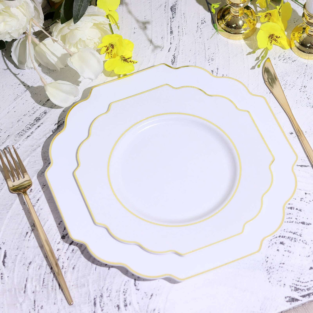 Elegant white plate with gold trim, styled with gold cutlery and floral accents.