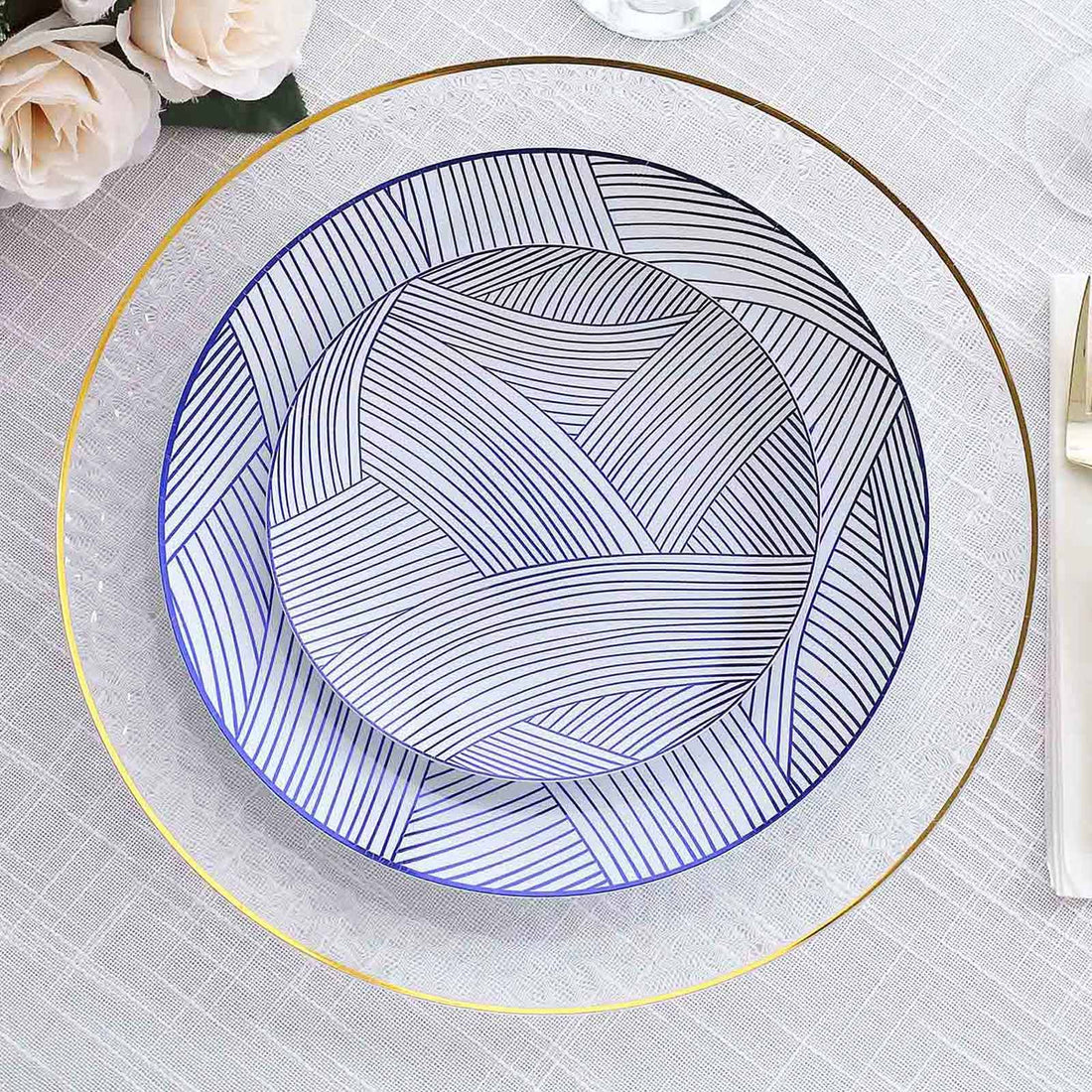 Decorative plates with intricate blue line patterns on a white table setting.