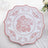 Decorative pink floral plate on a white tablecloth.