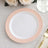 White plate with pink decorative rim on a textured tablecloth.
