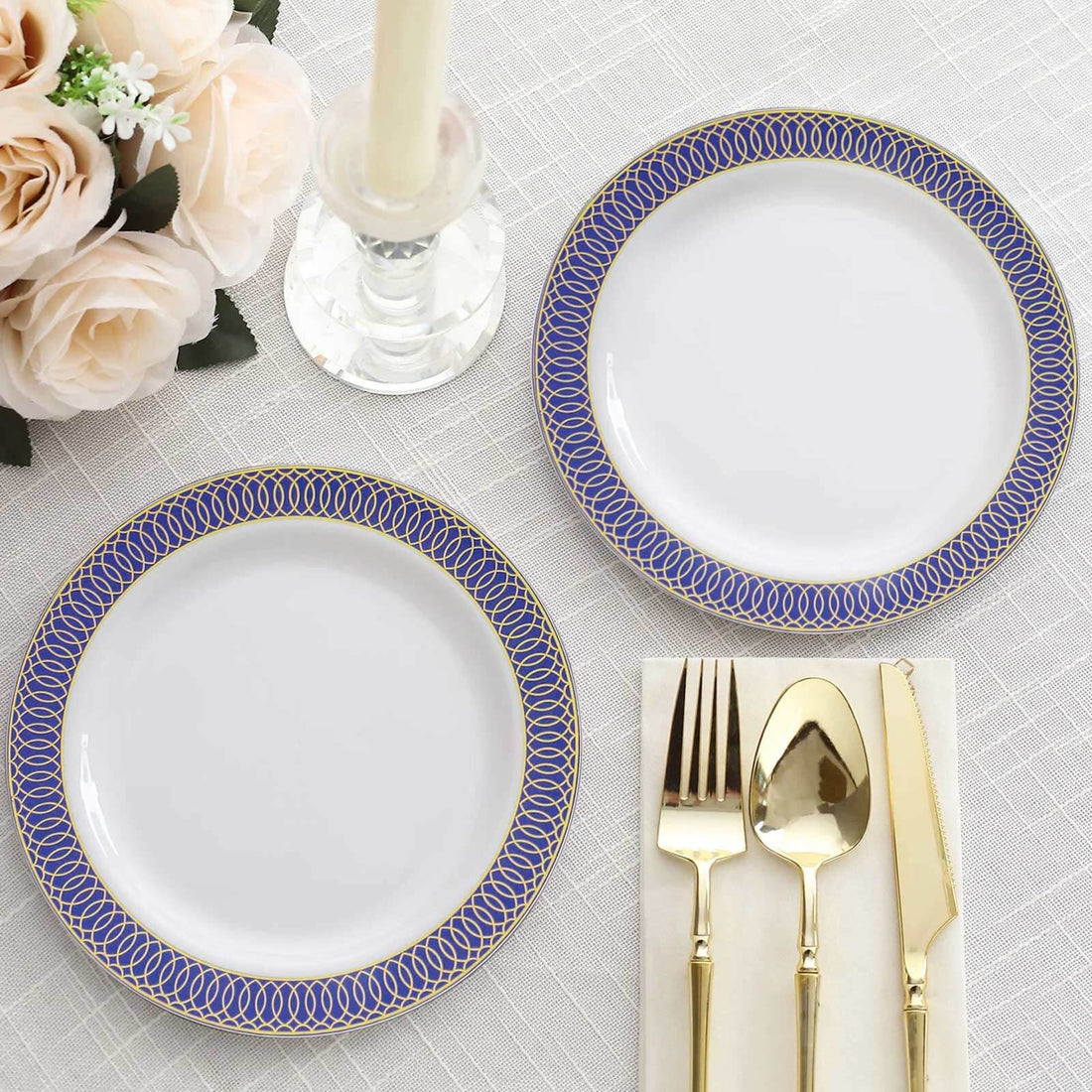 Elegant blue and gold rimmed dinner plates with gold cutlery on a table setting.
