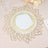 Elegant gold-striped dinner plate on decorative lace placemat.