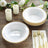 Elegant white bowls with gold beaded rim on a wooden table setting.