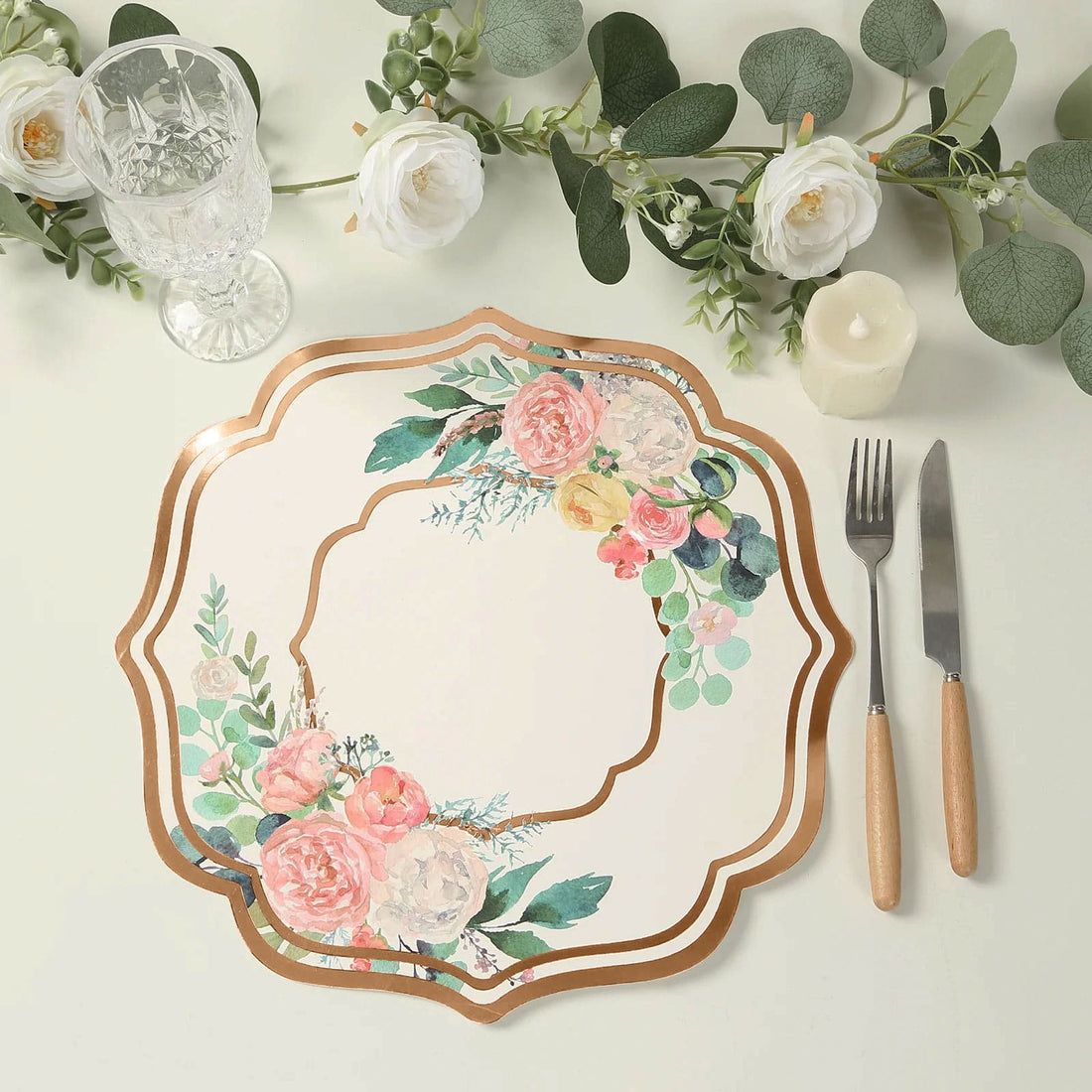 Floral decorative plate with gold trim on a table setting.