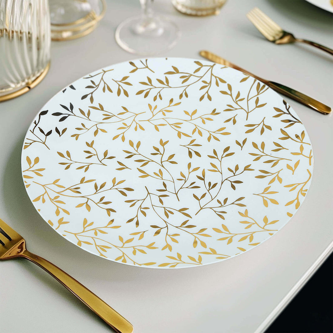 Elegant white plate with gold leaf design on a table setting.