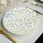 Elegant white plate with gold leaf design on a table setting.