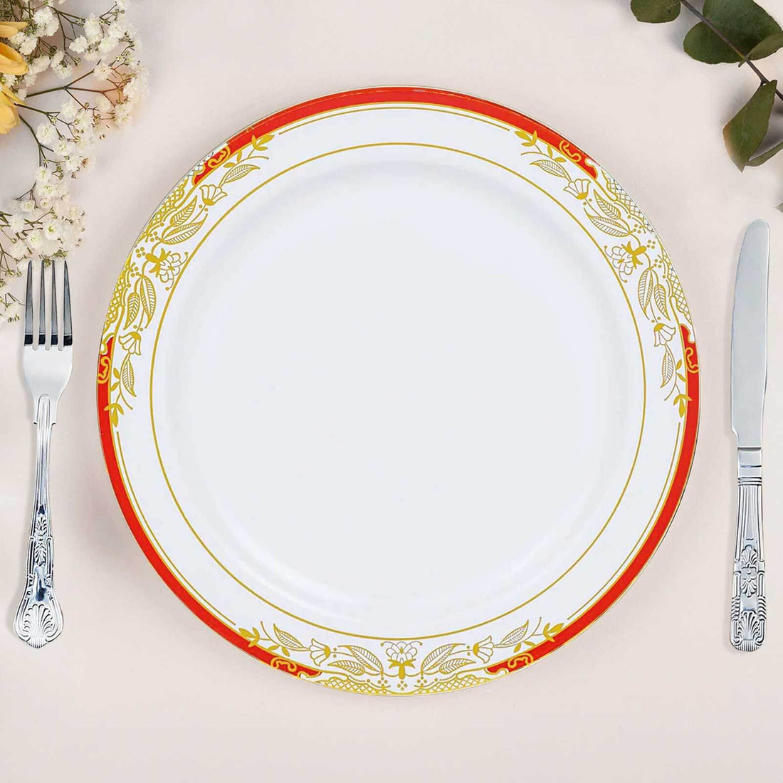 Elegant white plate with red and gold floral border, set on a neutral background.