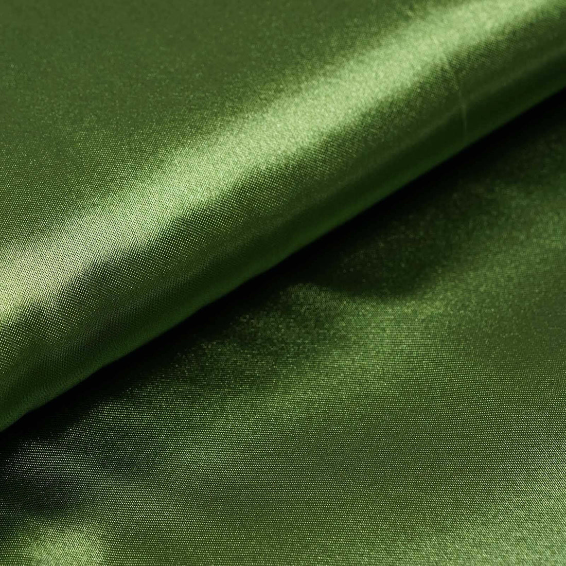 Shiny green fabric roll on a smooth surface. #whtbkgd